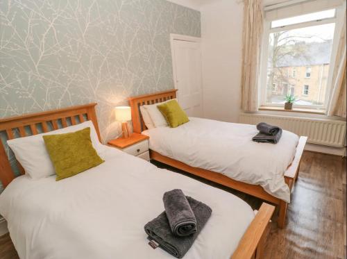 two beds sitting next to each other in a bedroom at Acacia House in Wolsingham