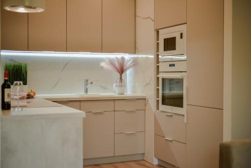 a white kitchen with a sink and a microwave at Better Place Modern Port Praski in Warsaw