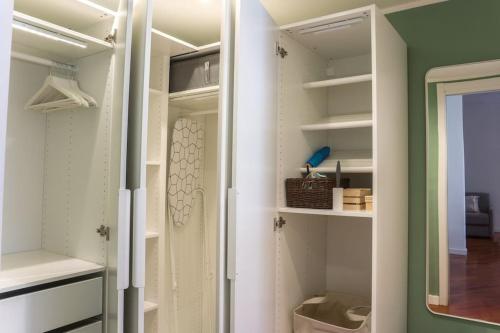 a walk in closet with white shelving at The Green House [Free Private Parking] in Milan
