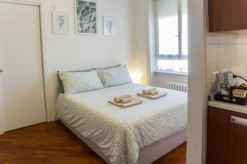 a small bedroom with a bed with two towels on it at The Green House [Free Private Parking] in Milan