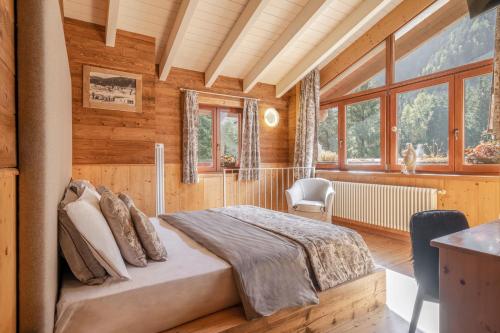 um quarto com uma cama num quarto com paredes de madeira em La Tana dell'orso Hotel & SPA em Ponte di Legno