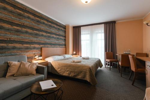 une chambre d'hôtel avec un lit et un canapé dans l'établissement Hotel Pod Figurą, à Ogrodzieniec
