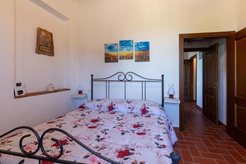 a bedroom with a bed with red flowers on it at San Lorenzo Agriturismo in Buonconvento