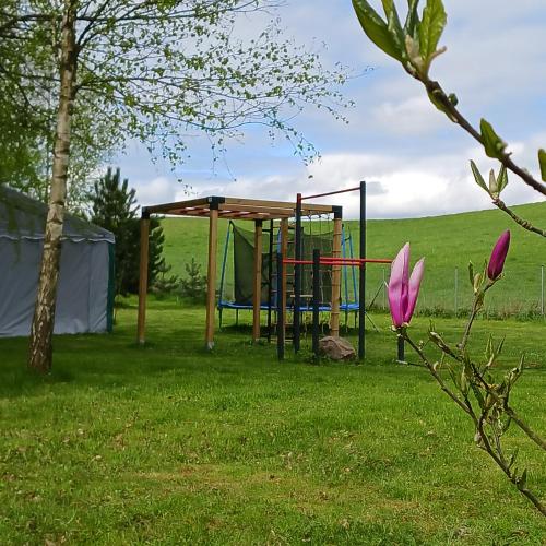 a playground in a field with a tent at Agroturystyka Pod Dębem in Jonkowo