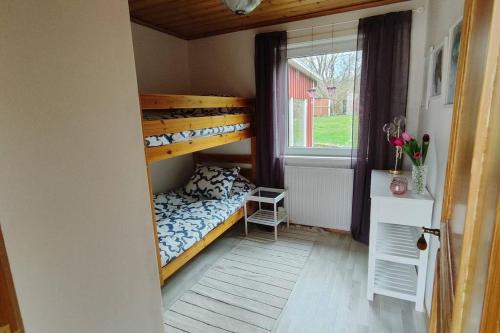 ein Schlafzimmer mit einem Etagenbett und einem Fenster in der Unterkunft Hus i Skärhamn när till hav och natur! in Utäng