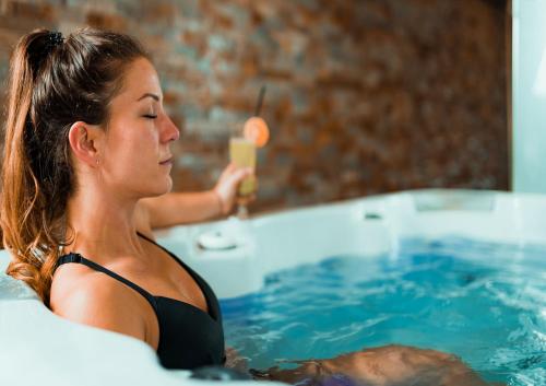 a woman in a bath tub with a glass of champagne at gyulai campingresort in Gyula