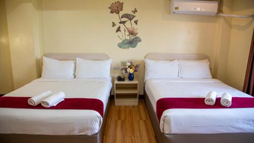 two beds in a hotel room with white pillows at 456 Hotel in Baguio