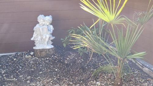 a statue of a little angel sitting in a garden at Anker Perla in Grömitz