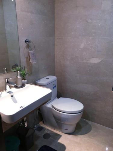 a bathroom with a white toilet and a sink at Menteng Park in Jakarta