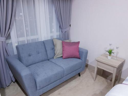 a blue couch with two pillows in a living room at Menteng Park in Jakarta