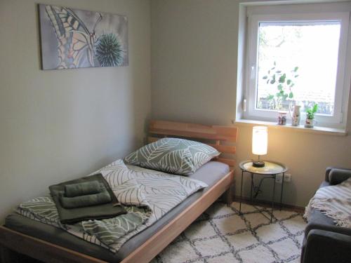 ein kleines Bett in einem Zimmer mit Fenster in der Unterkunft #3 Gemütliches ruhiges Zimmer mit Gartenblick Airport nah gelegen mit W-Lan Late Night Check in in Trunkelsberg