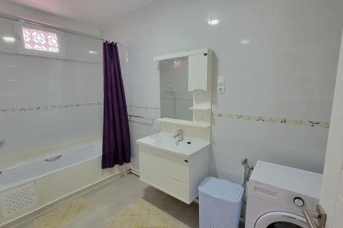 a bathroom with a sink and a tub and a toilet at Joli appartement au centre in Annaba