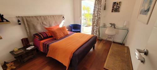 une chambre avec un lit avec une couverture orange dans l'établissement VILLA LA VALENTINE 2 chambres, à Salon-de-Provence