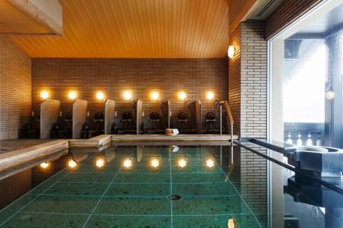 a pool in a house with lights in it at Sun Members Hirugano in Gujo