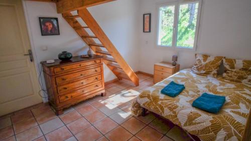 um quarto com uma cama com uma cómoda e uma escada em Chez Anais et Marc em Aouste-sur-Sye