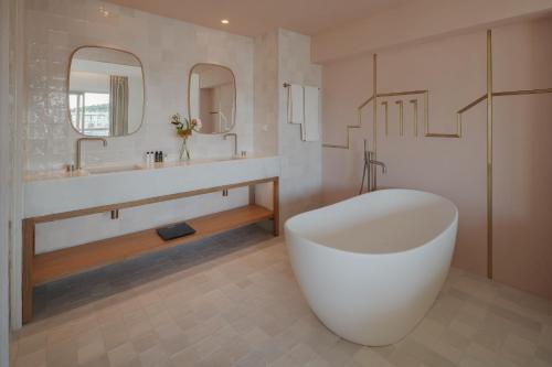 a bathroom with a large white tub and a sink at Coco-mat Athens BC in Athens
