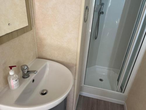 a bathroom with a sink and a shower at Pets Stay free 2 bedroom caravan at heacham beach in Hunstanton