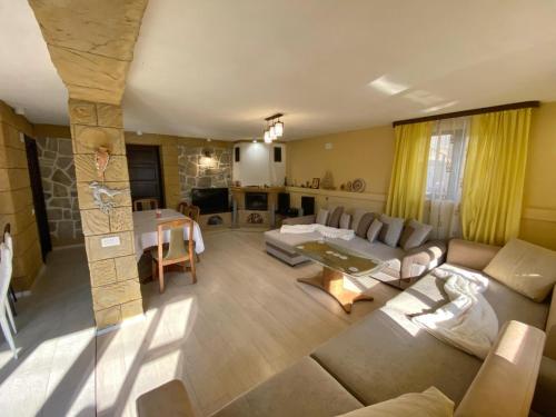 ein Wohnzimmer mit einem Sofa und einem Tisch in der Unterkunft Casa Polen Comarnic in Comarnic