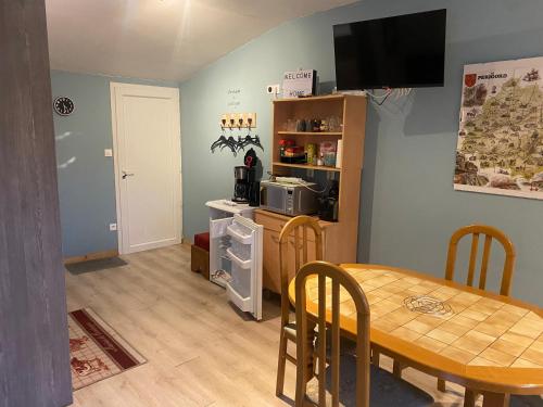 - une cuisine et une salle à manger avec une table et un four micro-ondes dans l'établissement Mini loft a la campagne dans une ancienne ferm, à Saint-Cyprien