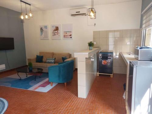 cocina y sala de estar con sofá y fogones en LGG Résidence, en Douala