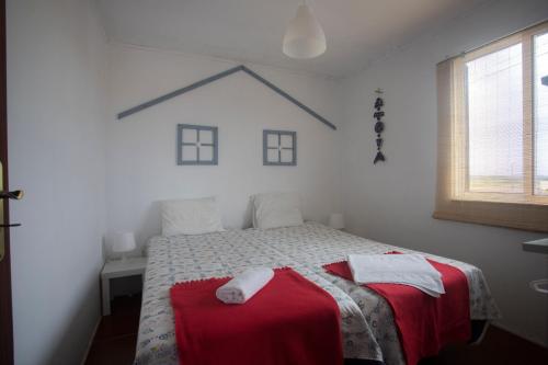 ein Schlafzimmer mit einem Bett mit zwei Handtüchern darauf in der Unterkunft Ria de Aveiro White House in Murtosa