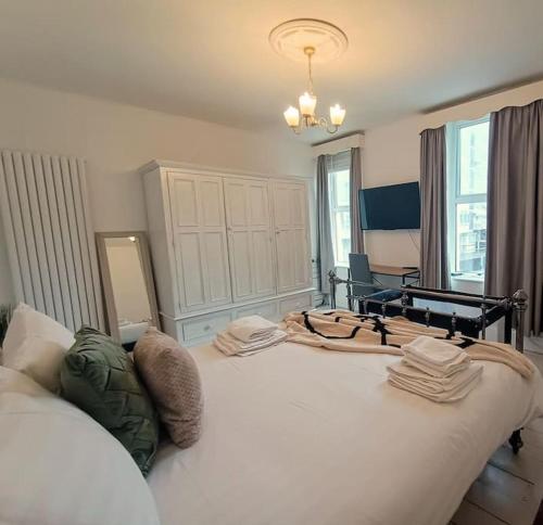a bedroom with a large white bed with towels on it at 4 Bed house Sea Views Benji's by the beach in Morecambe