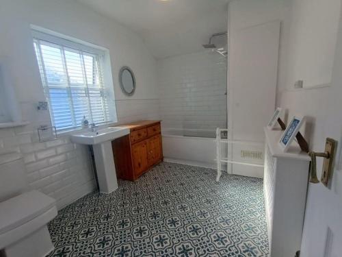 a white bathroom with a sink and a tub at 4 Bed house Sea Views Benji's by the beach in Bare