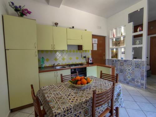 a kitchen with a table with a bowl of fruit on it at B&B Casa Mena in Vietri sul Mare