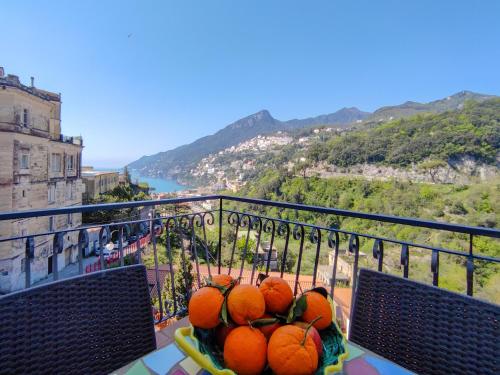 a bowl of oranges sitting on a table on a balcony at B&B Casa Mena in Vietri sul Mare