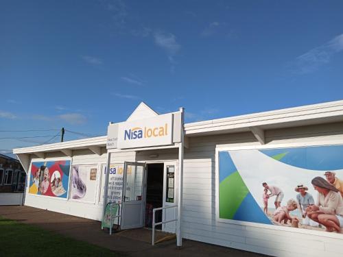 a nesslocal building with advertisements on the side of it at pets stay free 3 bedroom caravan at heacham beach in Heacham