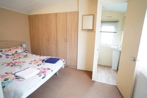 a small bedroom with a bed and a sink at 2 bedroom caravan in hunstanton free wi-fi in Hunstanton
