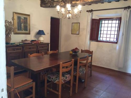 uma sala de jantar com uma mesa de madeira e cadeiras em Casa nel bosco a 10 minuti da Pistoia em Corbezzi