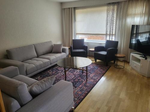 a living room with a couch and chairs and a television at Apartment 136 m2 with 3 bedrooms and 2 livingrooms, 2 floors, walking distance to all amenities in Närpiö