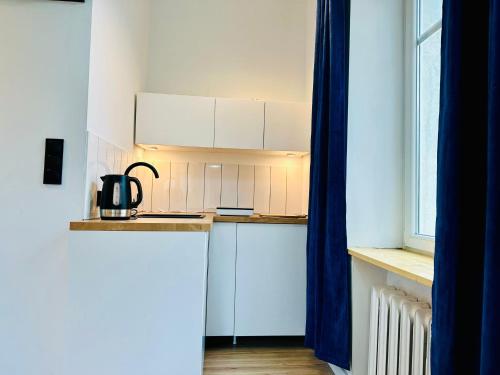 a kitchen with white cabinets and a counter top at Apartamenty Maj Sokołowsko in Sokołowsko