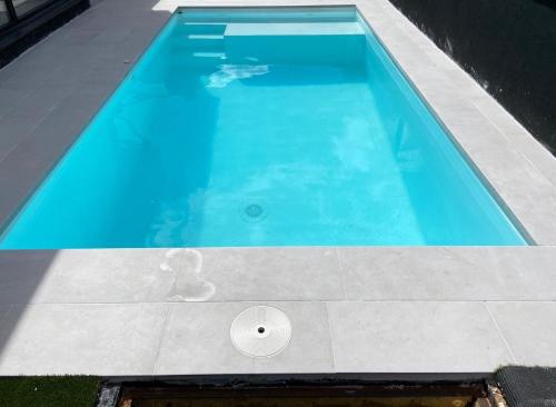 Remedios de Luna في Antimio de Arriba: حمام سباحة ازرق كبير على جانب المنزل