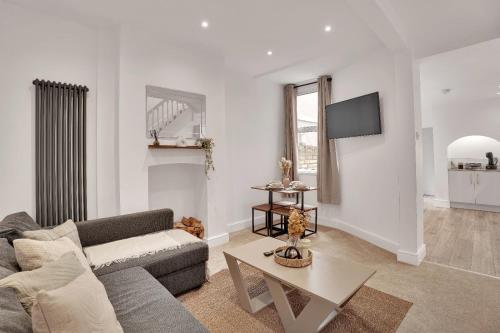 a living room with a couch and a table at The Bay Escape -Lovely 3bd house in Cardiff