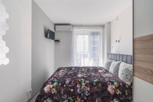 1 dormitorio con 1 cama con colcha de flores en HappyLupa en Budapest
