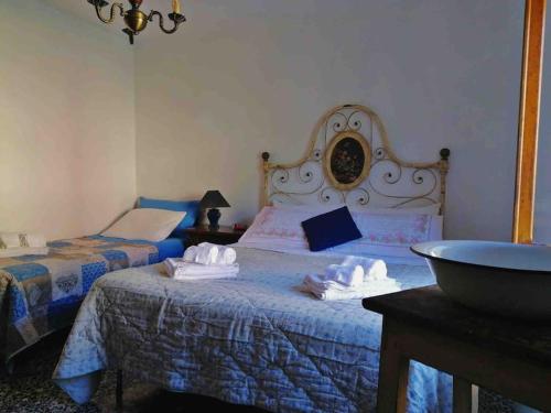 Casa Irene per famiglie e gruppi con piscina في Lugliano: غرفة نوم بها سريرين مع مناشف عليهما
