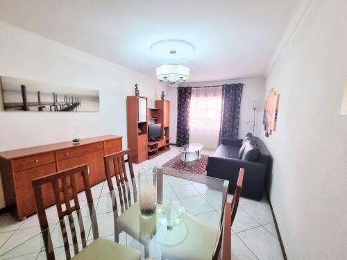 a dining room and living room with a table and chairs at Apartamento Real Delux in Vila Real de Santo António