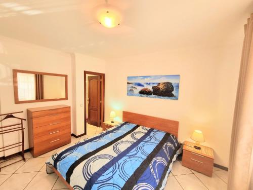 a bedroom with a bed and a painting on the wall at Apartamento Real Delux in Vila Real de Santo António