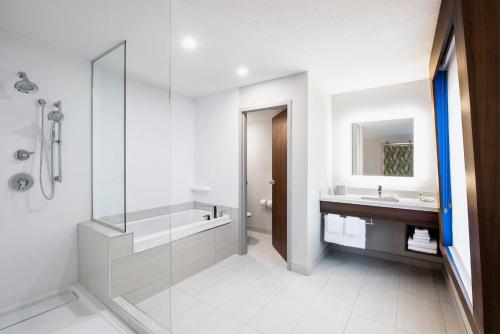 a bathroom with a glass shower and a sink at Holiday Inn Express Hotel & Suites Saskatoon by IHG in Saskatoon