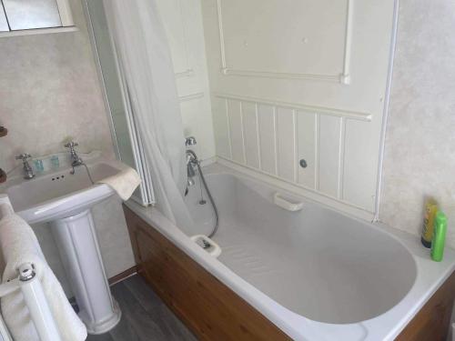 een witte badkamer met een bad en een wastafel bij 2 bedroom two bathroom sunset lodge heachambeach in Heacham