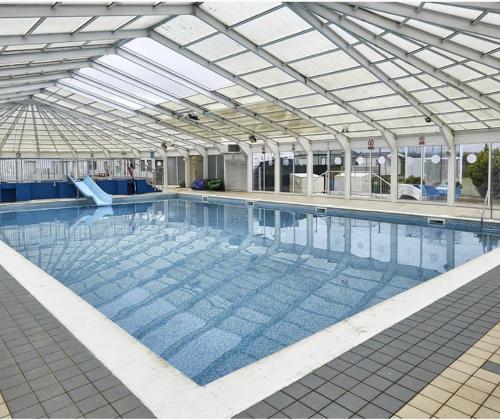 a large swimming pool with a glass ceiling at pets stay free 8 berth lux van heacham beach in Heacham