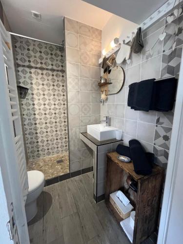 une salle de bain avec toilettes, un lavabo et une douche dans l'établissement La petite maison, à Gasny