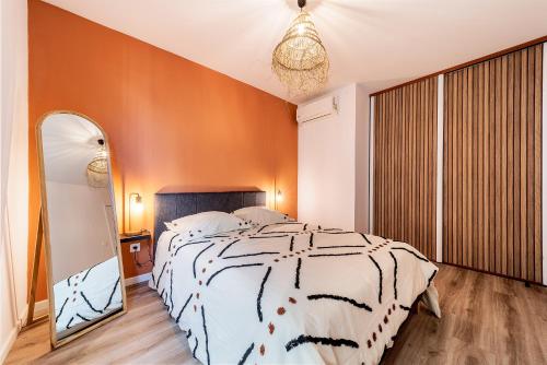 a bedroom with a large bed and a mirror at Mon Cosy Saint-Pierre in Saint-Pierre