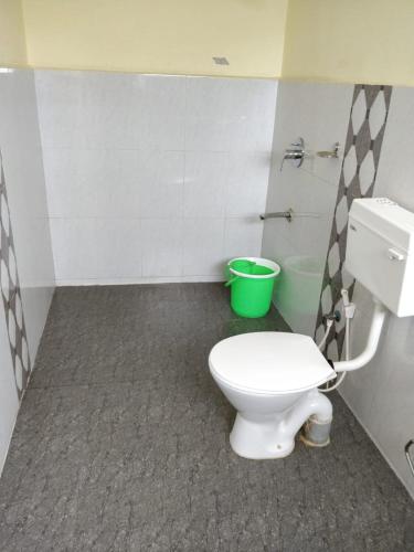 コダイカナルにあるFLGHR Crescent Parkのバスルーム(白いトイレ、緑のバケツ付)