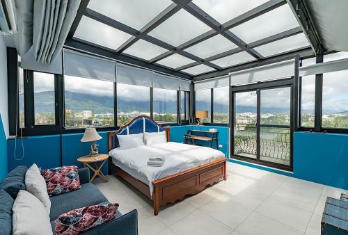 - une chambre avec un lit, un canapé et des fenêtres dans l'établissement Moritz Homestay, à Hualien