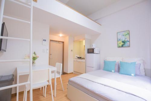 a white bedroom with a bed and a desk at 閑静な住宅街_暖かく居心地の良いデザイン EoW-7 in Tokyo