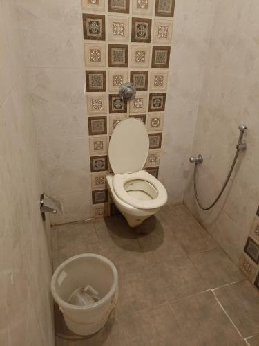 a bathroom with a toilet and a trash can at Hotel Ganges in Haridwār