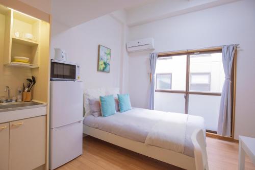 a small bedroom with a bed and a window at 閑静な住宅街_暖かく居心地の良いデザイン EoW-7 in Tokyo